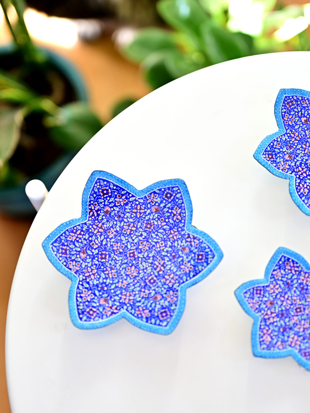 Enhance your home with this set of three Persian copper enamel  (Minakari) star dishes, hand-painted with intricate floral designs in vibrant blue,