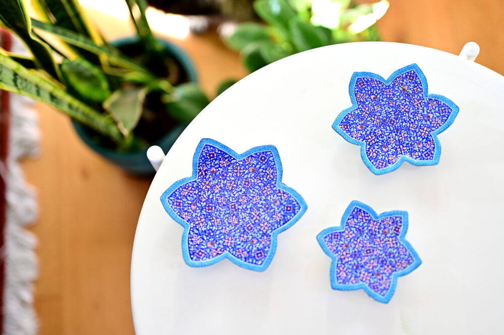 Enhance your home with this set of three Persian copper enamel  (Minakari) star dishes, hand-painted with intricate floral designs in vibrant blue,