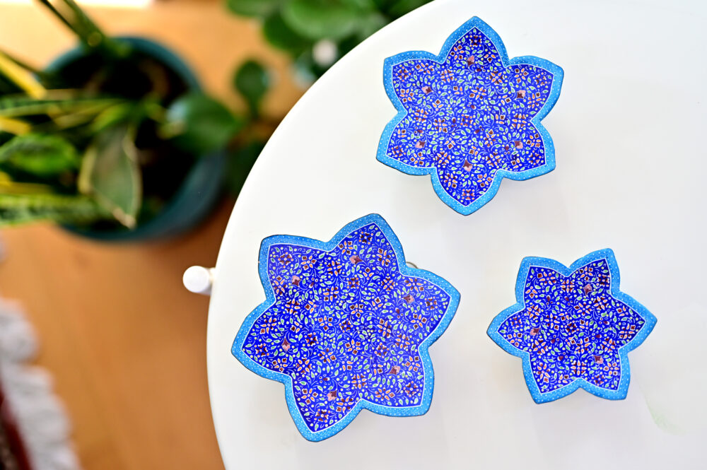 Enhance your home with this set of three Persian copper enamel  (Minakari) star dishes, hand-painted with intricate floral designs in vibrant blue,