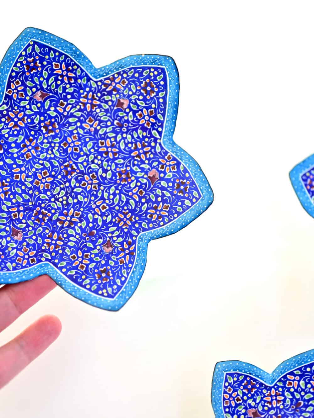 Enhance your home with this set of three Persian copper enamel (Minakari) star dishes, hand-painted with intricate floral designs in vibrant blue,