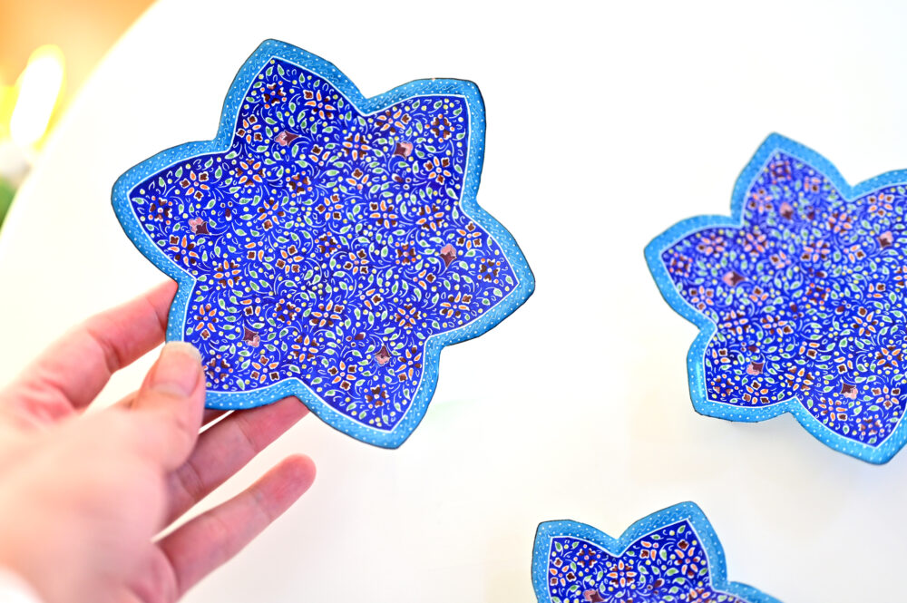Enhance your home with this set of three Persian copper enamel  (Minakari) star dishes, hand-painted with intricate floral designs in vibrant blue,