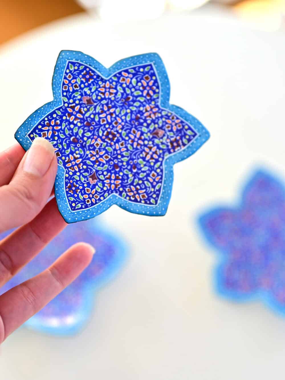 Enhance your home with this set of three Persian copper enamel (Minakari) star dishes, hand-painted with intricate floral designs in vibrant blue,