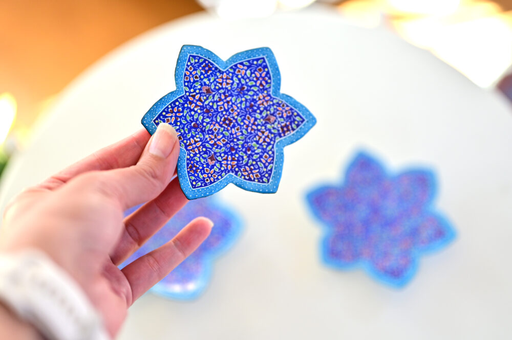 Enhance your home with this set of three Persian copper enamel  (Minakari) star dishes, hand-painted with intricate floral designs in vibrant blue,